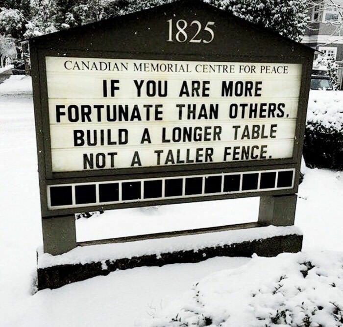photo d'un panneau "Canadian memorial center for peace - If you are more fortunate that others, build a longer table, not a taller fence."