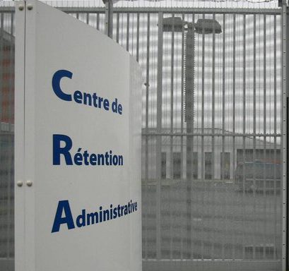photo d'un panneau indiquant Centre de Rétention Administrative et grille fermant l'accès