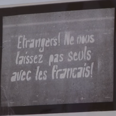 photo d'un tableau où il est inscrit "Etrangers ! ne nous laissez par seuls avec les français"